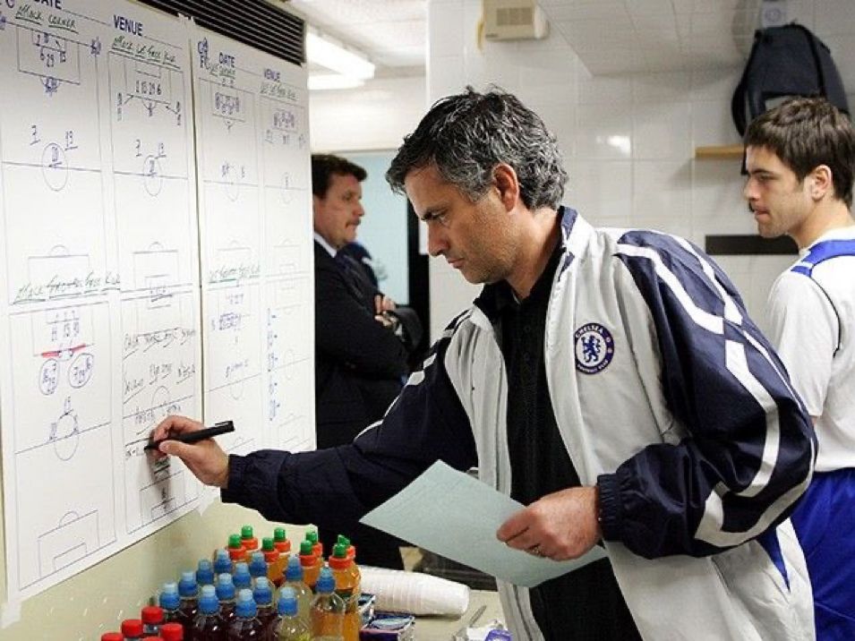 José Mourinho analysing match tactics on a whiteboard.